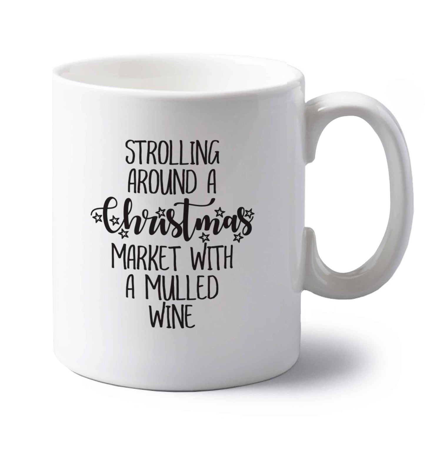Strolling around a Christmas market with mulled wine left handed white ceramic mug