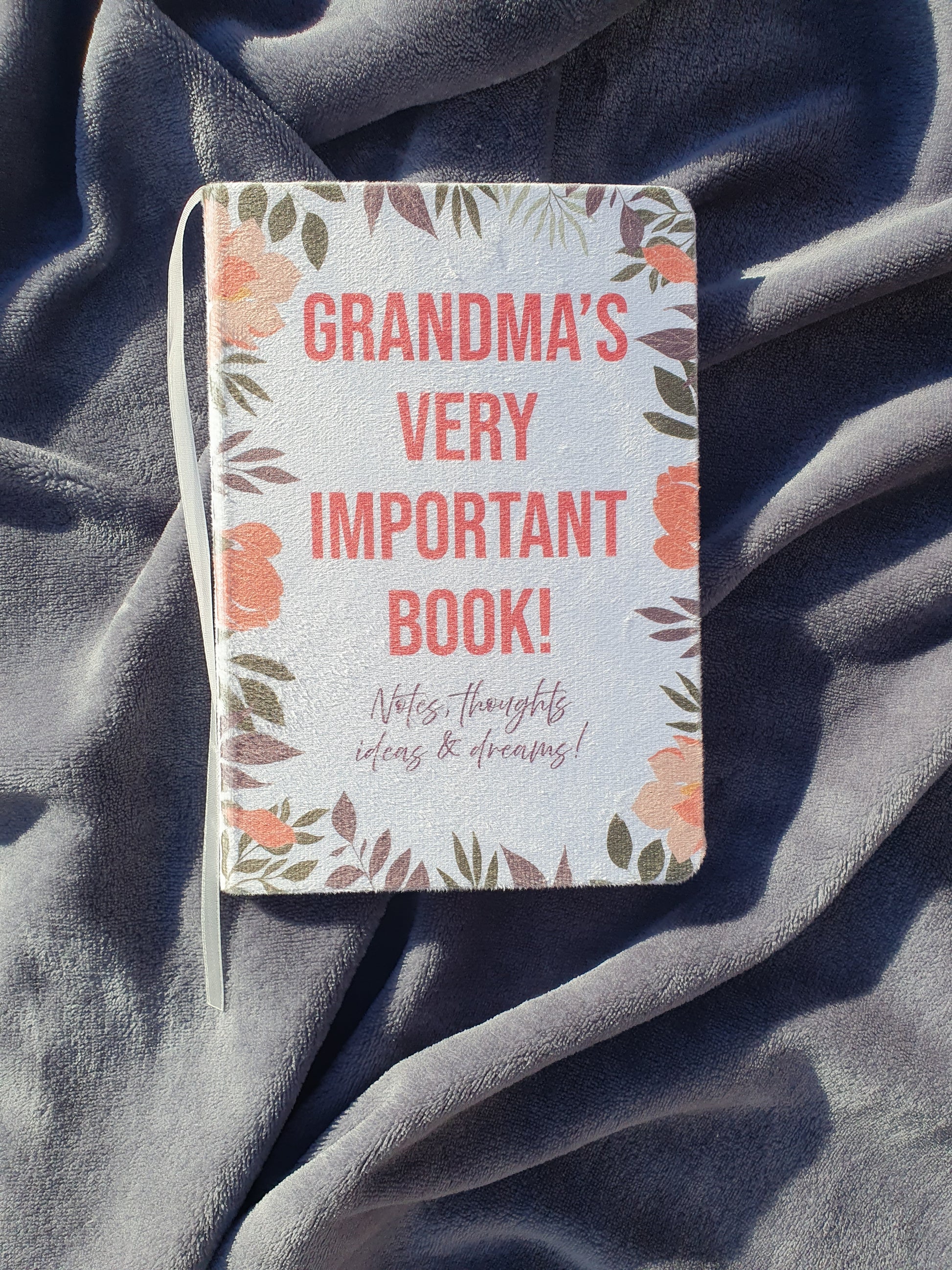 Another image of the notebook already printed it says 'Grandma's Very Important Book' on a soft fabric background