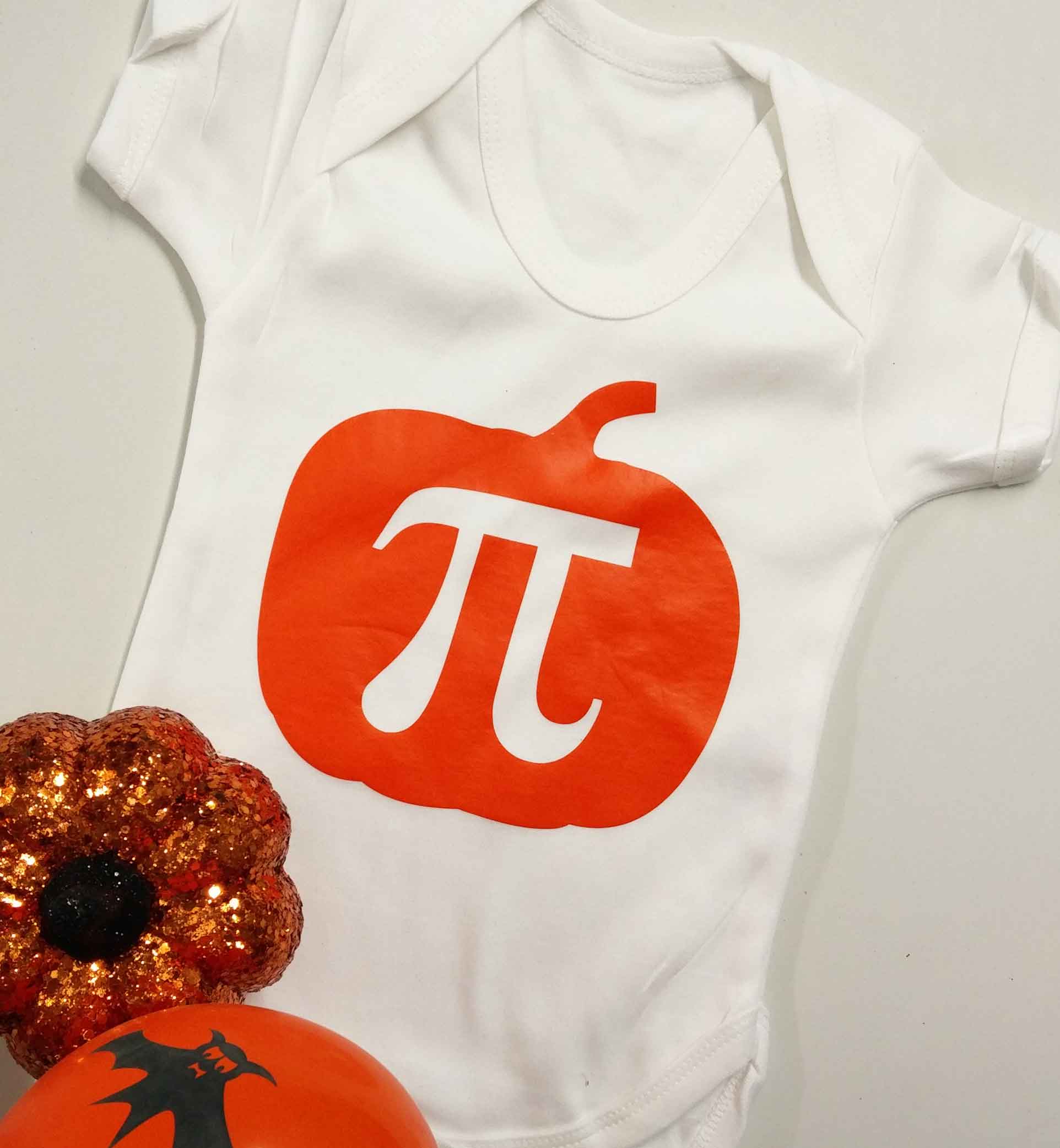 White baby vest with a pumpkin on it and a pi symbol in the middle
