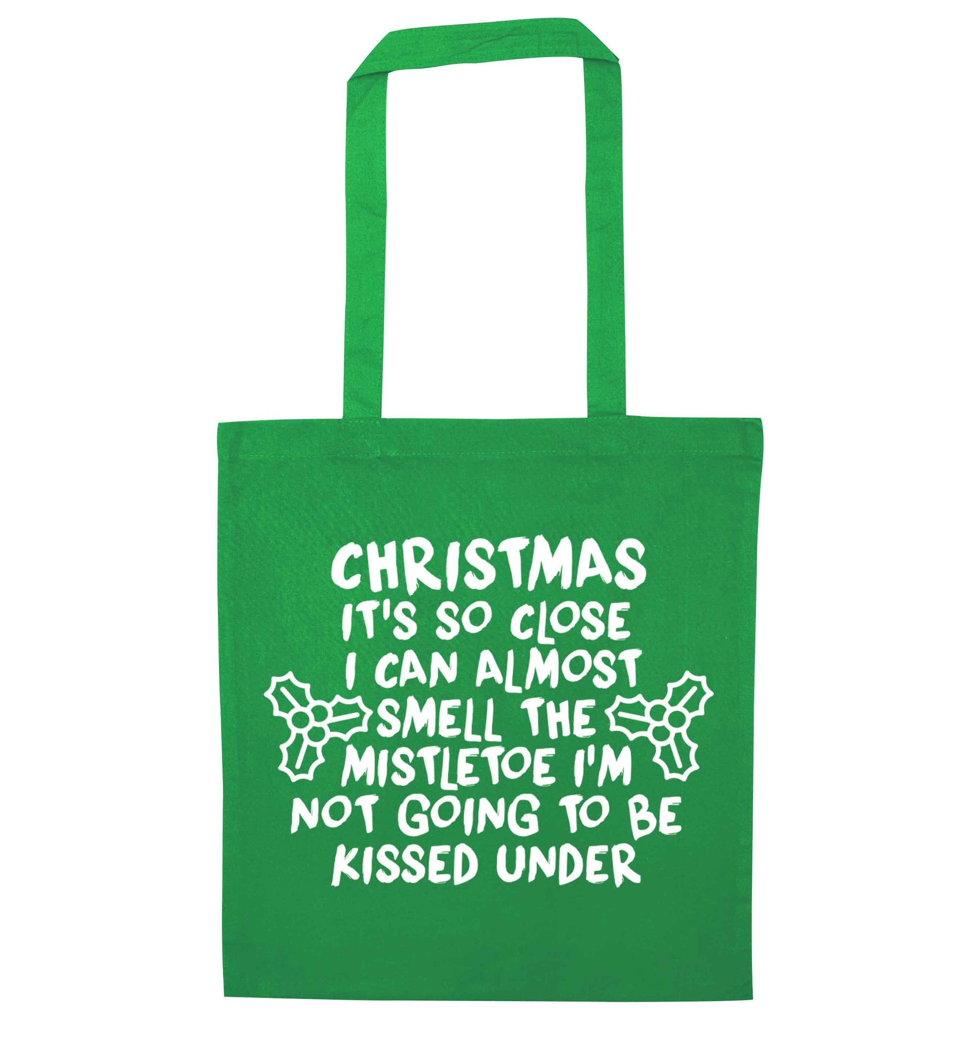 Christmas it's so close I can almost smell the misteltoe I'm not going to be kissed under green tote bag